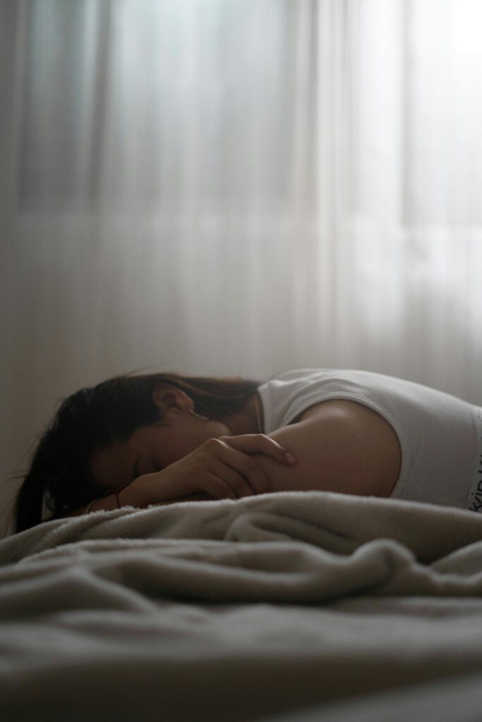 Femme blanche triste sur son lit.