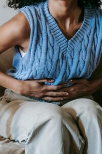 Femme métisse qui a mal au ventre