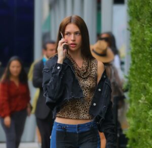 Femme blanche rousse marchant dans la rue avec un téléphone