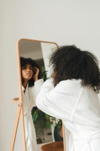 Femme métisse qui se regarde dans le miroir.