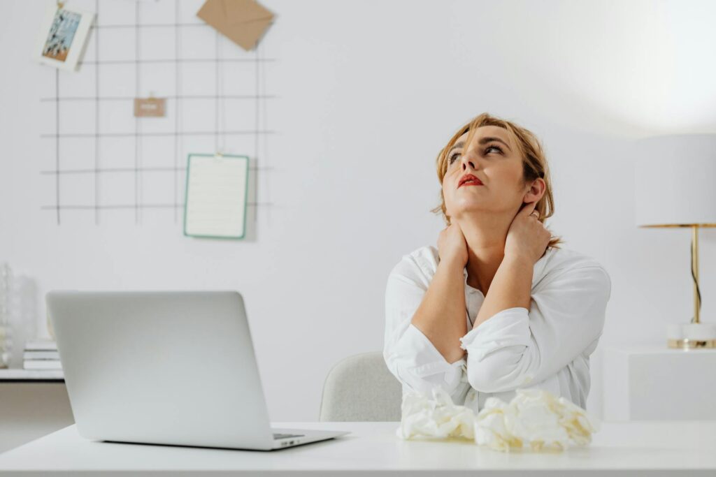 Femme blanche stressée blonde à son bureau.