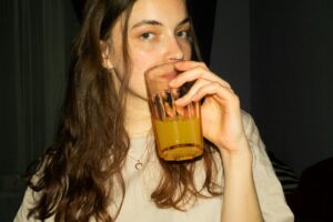 Femme brune qui boit un jus d'orange