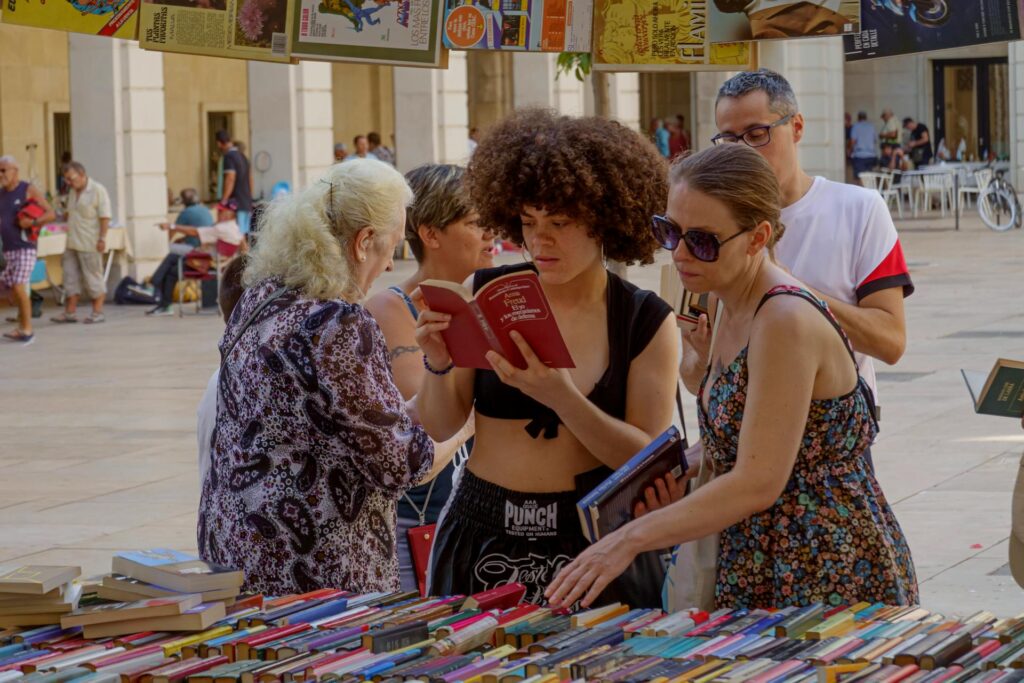 Femme métisse cheveux afro qui lit un livre dans un festival