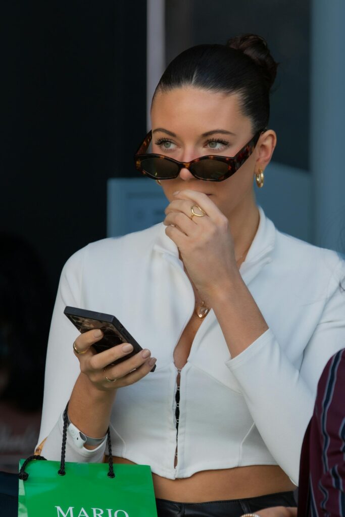 Femme blanche avec un chignon sur son téléphone