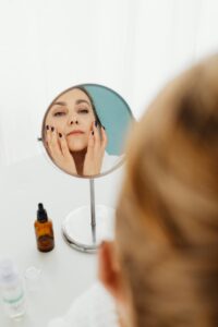 Femme blanche brune qui se regarde dans un miroir.