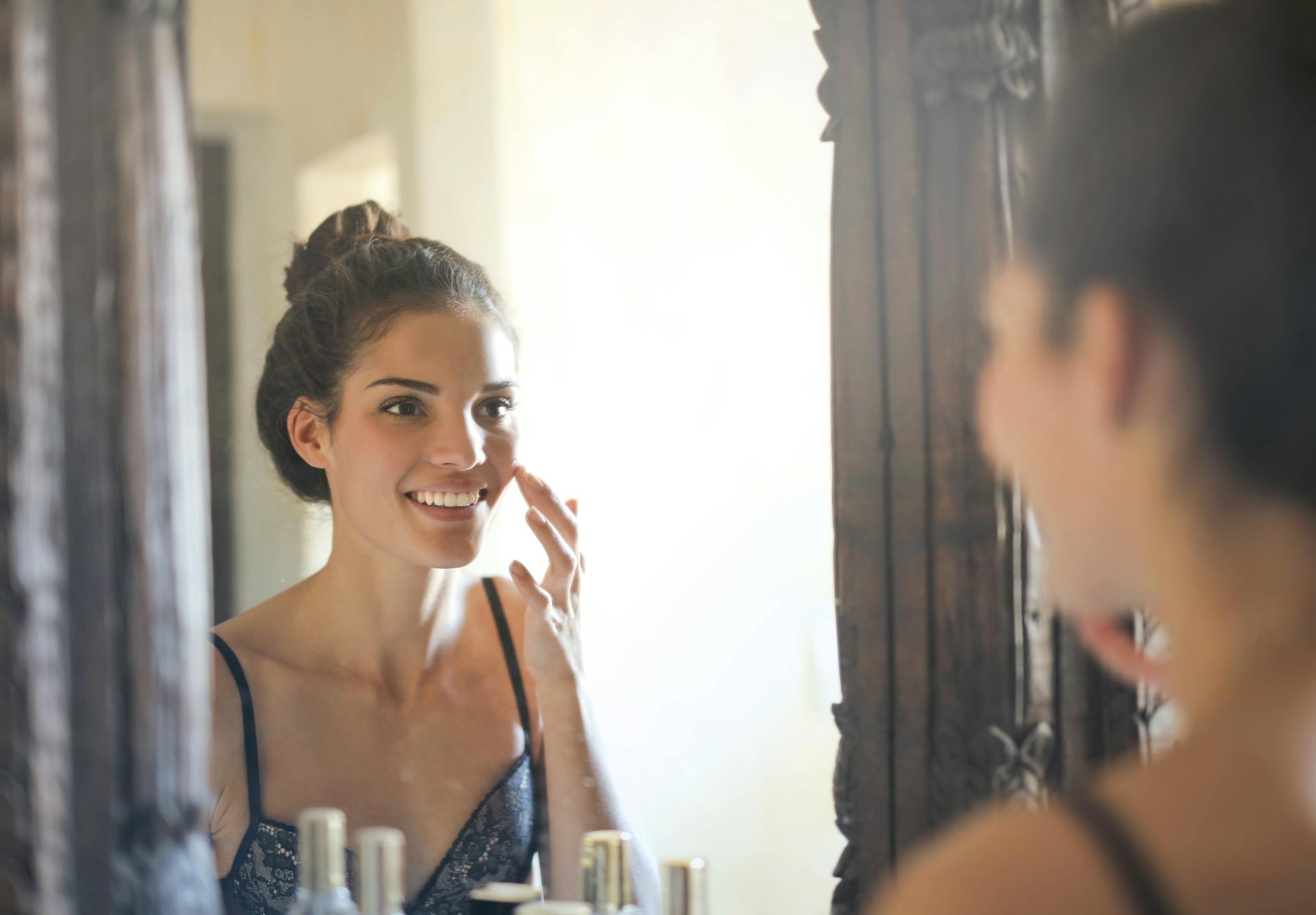 Femme métisse brune qui sourit devant le miroir