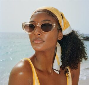 Femme noire avec un foulard et des lunettes de soleil