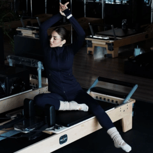 Femme blanche en tenue de sport qui fait du Pilates