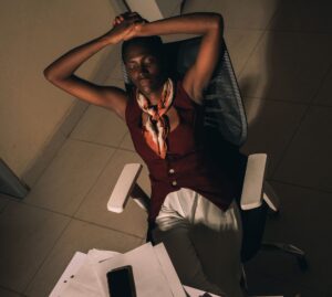 Femme noire en train de dormir au bureau au travail