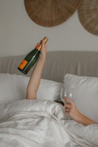 Femme dans son lit avec du champagne