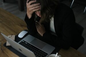 Une femme stressée au travail devant son ordinateur