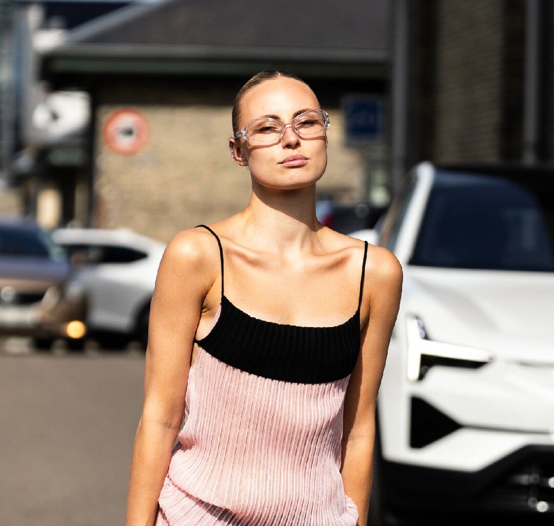 Femme blanche blonde avec des lunettes de vue portant une robe en street style