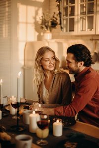 Femme blanche blonde et homme blanc brun à un dîner aux chandelles