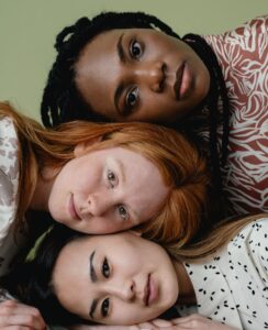 Une femme noire, une femme rousse et une femme asiatique