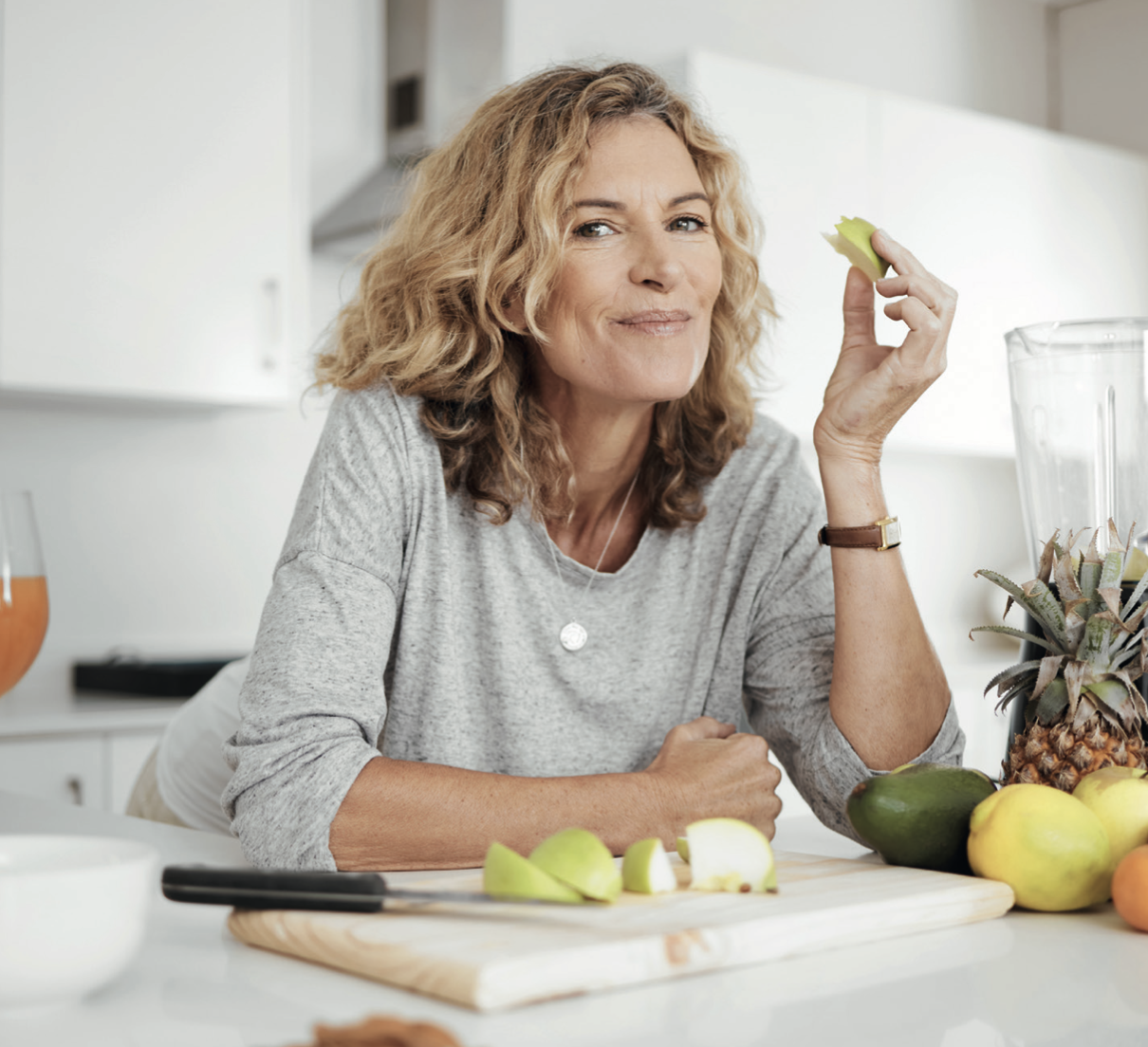 femme blanche qui sourit en mangeant une pomme