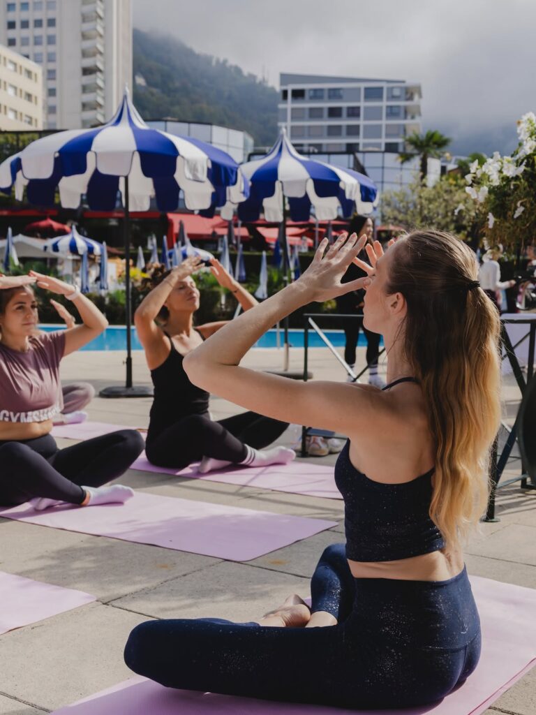 groupe de femmes faisant du pilates au bord du piscine