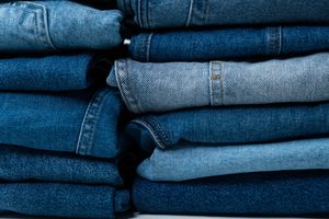 Gros plan sur une pile de jeans en denim bleu montrant différentes textures et nuances.